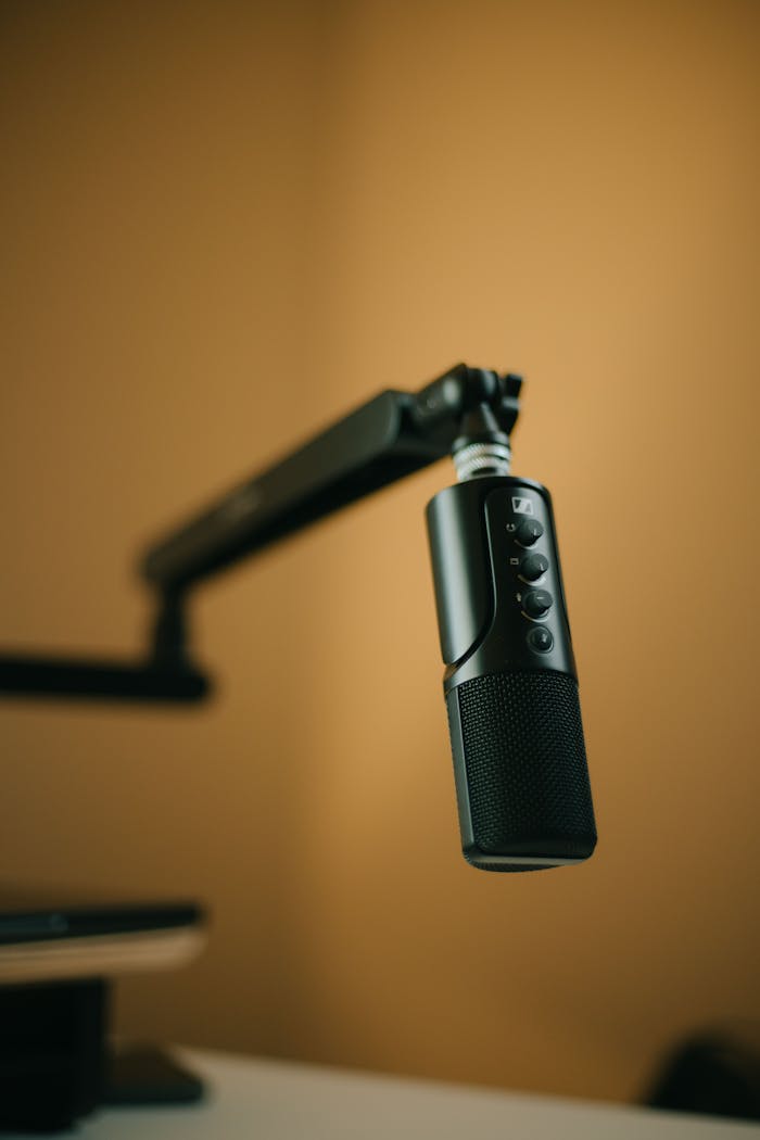 why-choose-us A sleek professional microphone on a boom arm in a minimalist studio.